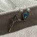 Rosary bracelet with clear beads and religious charm on a textured surface