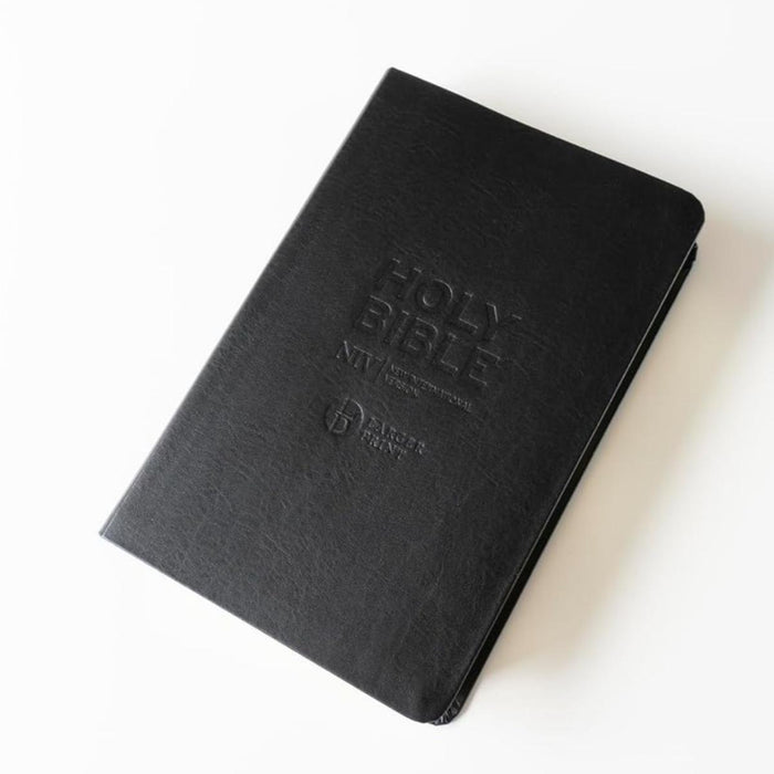 A black textured leather-bound Holy Bible, New International Version, with the title embossed on the cover, shown on a clean white background.