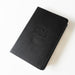 A black textured leather-bound Holy Bible, New International Version, with the title embossed on the cover, shown on a clean white background.