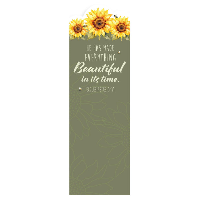 A tall, narrow decorative card or print with a sage green background, featuring three yellow sunflowers at the top and the quote 'HE HAS MADE EVERYTHING Beautiful in its time. ECCLESIASTES 3:11' in white text.
