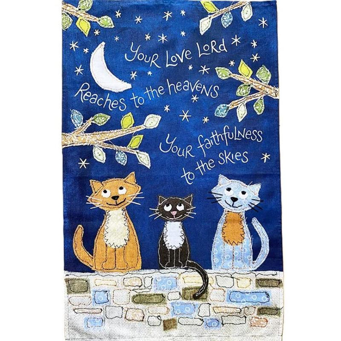 Decorative towel with cats on a stone wall against a night sky with stars and moon.