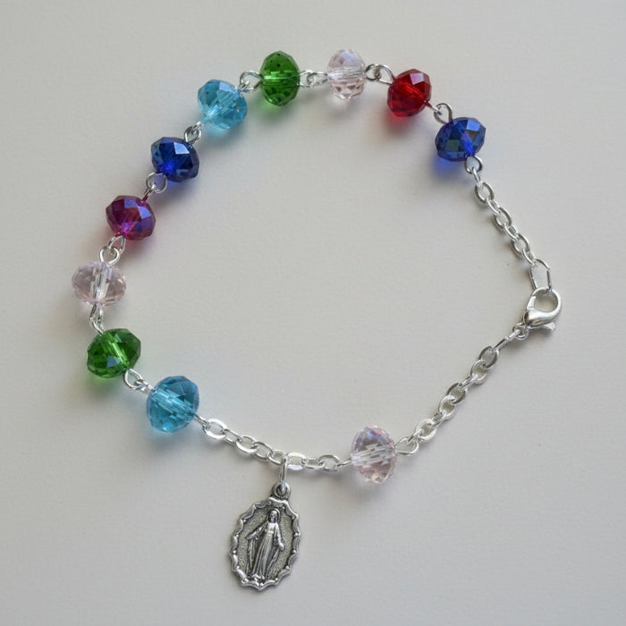 Colorful beaded bracelet with a silver charm on a wooden surface