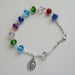 Colorful beaded bracelet with a silver charm on a wooden surface