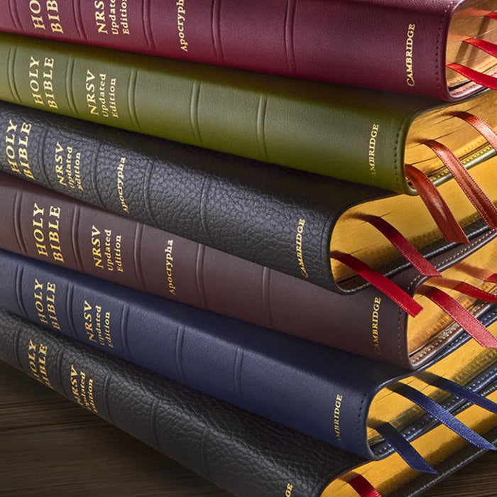 Stack of leather-bound books with visible branding on a wooden surface