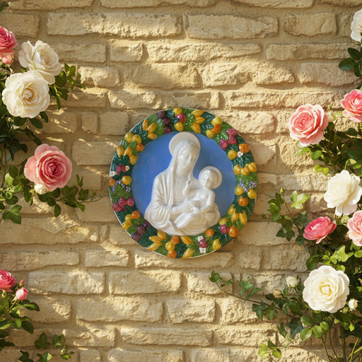 Decorative plate with a religious scene of a woman holding a child, surrounded by colorful fruit and flowers.