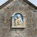 Decorative plaque with a classical design of a woman holding a child against a blue background