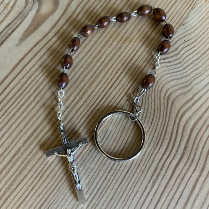 Wooden rosary with a cross and keychain on a wooden surface