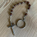 Wooden rosary with a cross and keychain on a wooden surface