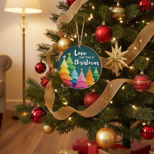 Round hanging ornament with a colorful Christmas tree illustration and the phrase “Love Came Down at Christmas” on a dark teal background.