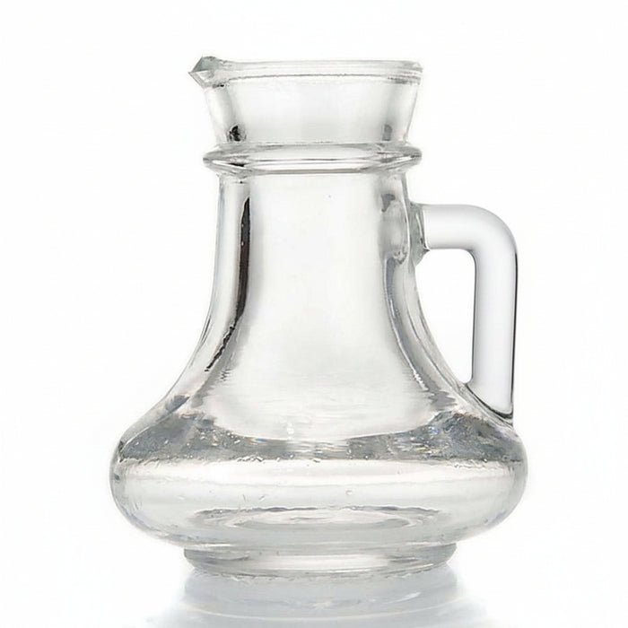 Clear glass pitcher with a curved handle and pouring spout, shown on a white background.