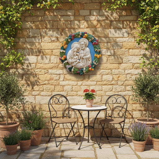 Decorative wall plaque featuring a religious scene with a couple and child, surrounded by fruits and flowers.