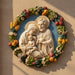 Decorative wall plaque featuring a religious scene with a couple and child, surrounded by fruits and flowers.