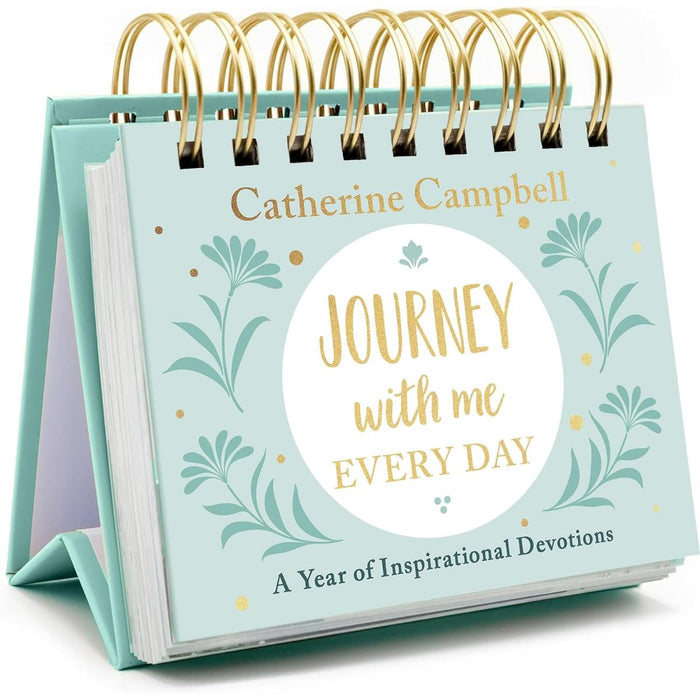 A spiral-bound desk devotional book titled 'Journey with me Every Day' by Catherine Campbell, featuring a mint green cover with gold lettering and botanical illustrations, shown standing on its side.