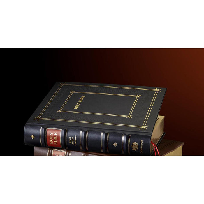 A black Holy Bible with gold embossed detailing on the spine and cover, resting on top of other books against a dark brown gradient background.