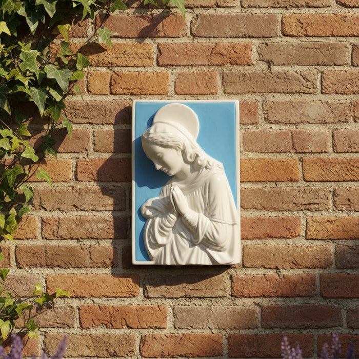 White religious sculpture of a woman on a blue background