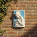 White religious sculpture of a woman on a blue background