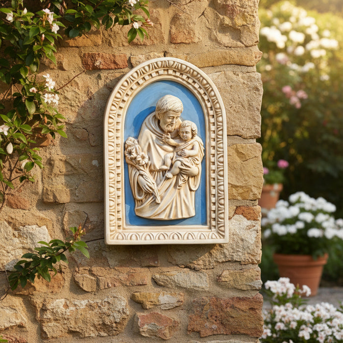 Decorative plaque with a religious scene of a man holding a child against a blue background, framed in beige.