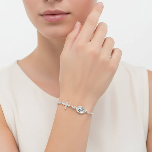 Silver bracelet with a cross charm on a white background