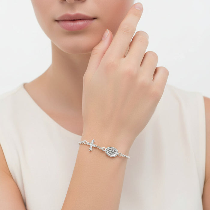 Silver bracelet with a cross charm on a white background