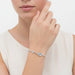 Silver bracelet with a cross charm on a white background